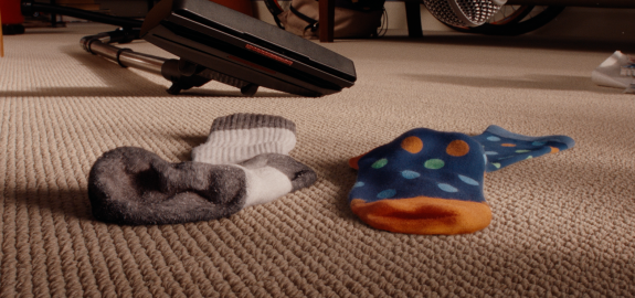 Simon & Mike, a pair of odd socks on a loop carpet